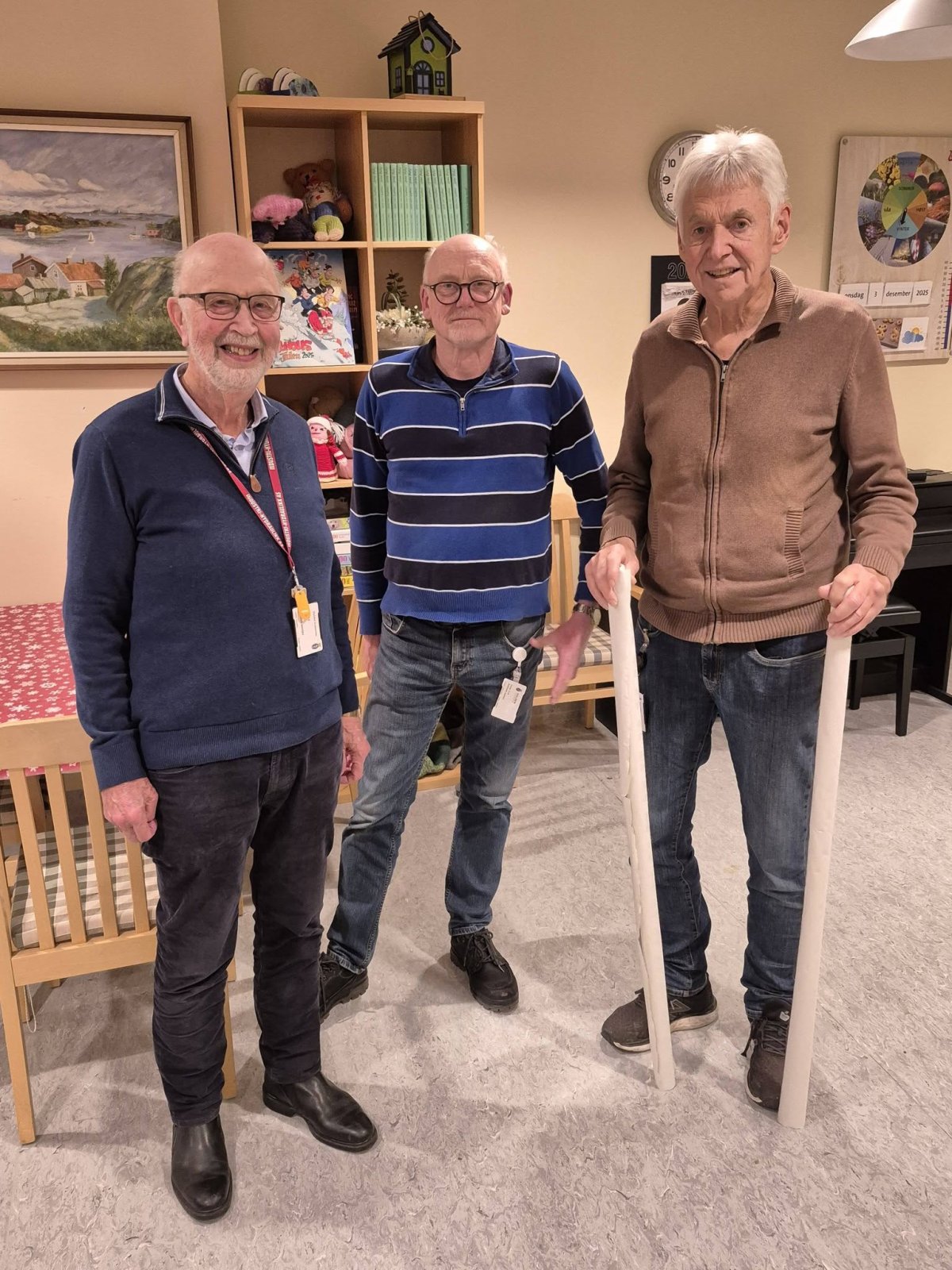 Tre frivillige menn med store lys på Solheim senter