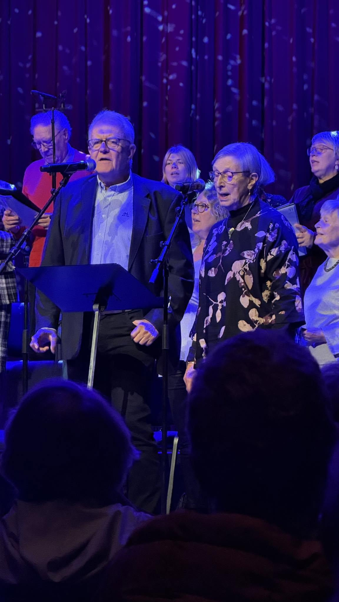 Solister ved mikrofonene under julekonserten i Brygga kultursal