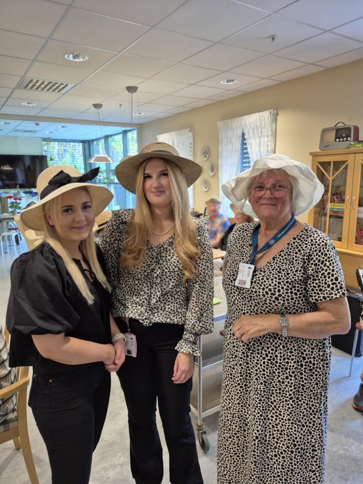 Tre blide hjelpere med sommerhatter